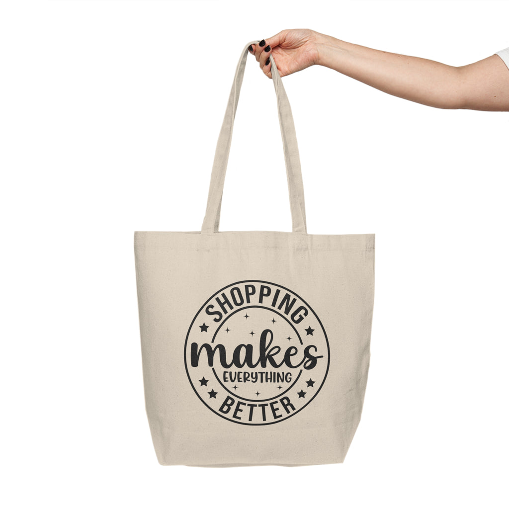 Beige tote bag with 'Shopping makes everything better' text on a white background
