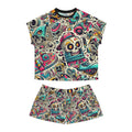 A two-piece women's pyjamas set consisting of a short-sleeve crop top and matching shorts, both featuring a vibrant, all-over cartoon graphic print of skulls, sneakers, and retro tech motifs on a cream background.