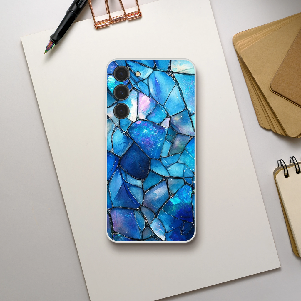 Phone case with blue mosaic design on a white surface with stationery items.