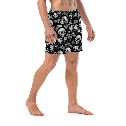 Person wearing black swim shorts with white graphic design on a white background