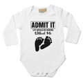 White baby onesie with black text and footprints on a white background
