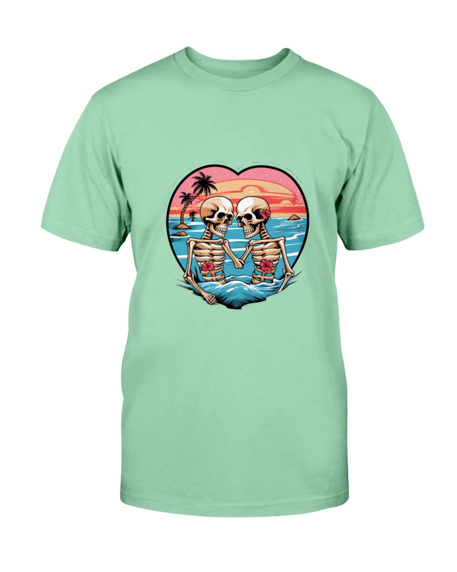 Light green t-shirt with a graphic of two skeletons holding hands on a beach, set against a heart-shaped sunset sky.
